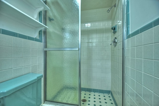 bathroom featuring tiled shower and tile walls