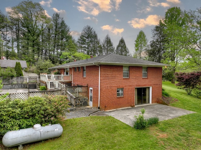 rear view of house with a yard, a patio, and a deck