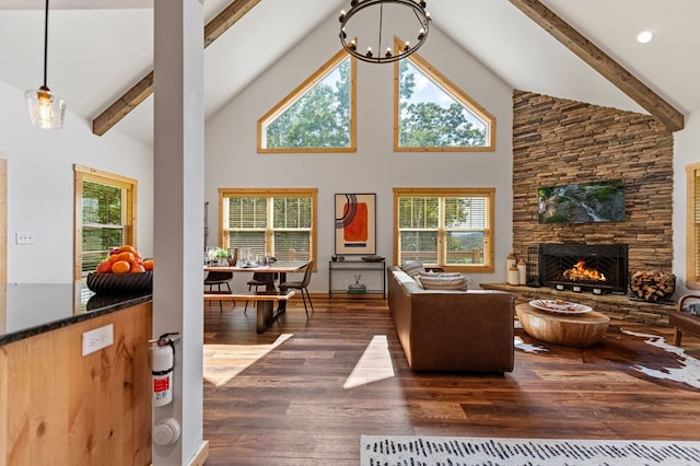 living room with plenty of natural light, a stone fireplace, dark wood-type flooring, and high vaulted ceiling