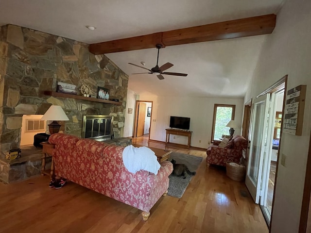 living room featuring hardwood / wood-style flooring, a fireplace, lofted ceiling with beams, and ceiling fan