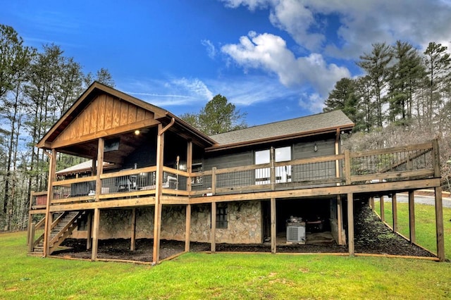 back of property featuring a deck and a lawn