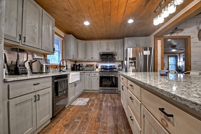 kitchen featuring dark hardwood / wood-style flooring, pendant lighting, wooden walls, wood ceiling, and appliances with stainless steel finishes