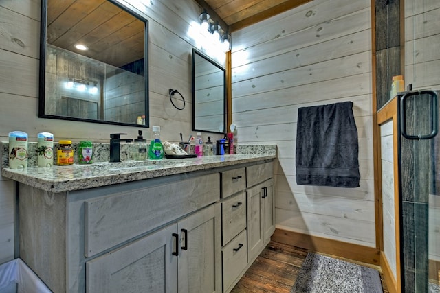 bathroom with hardwood / wood-style flooring, vanity, wood walls, and wooden ceiling