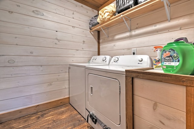 laundry room with wooden walls and washing machine and clothes dryer