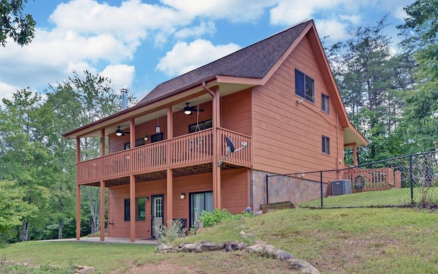 rear view of property with a balcony and a lawn