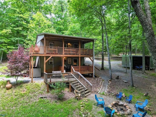 view of front of house with a wooden deck and a fire pit