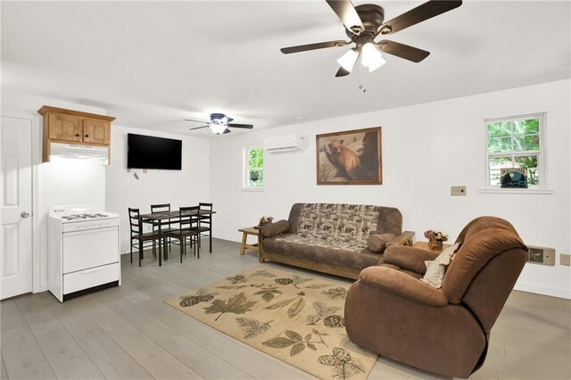 living room with a wall mounted AC, ceiling fan, and hardwood / wood-style floors