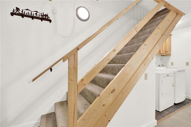 stairway featuring washing machine and dryer and hardwood / wood-style flooring