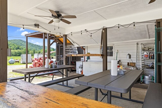 view of patio with a mountain view, outdoor dining area, and ceiling fan