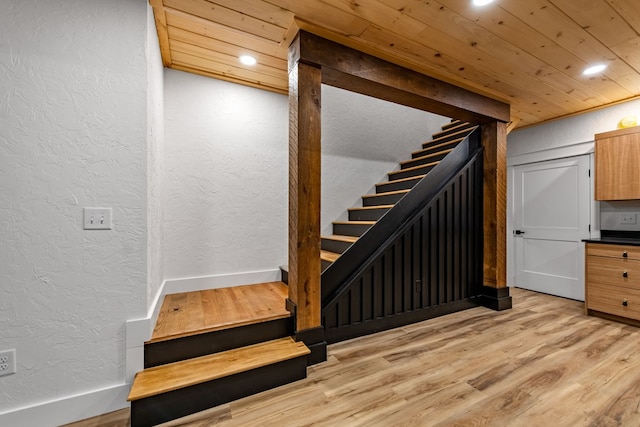 staircase featuring wood-type flooring and wooden ceiling