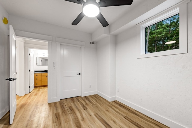 unfurnished bedroom with ceiling fan and light hardwood / wood-style flooring