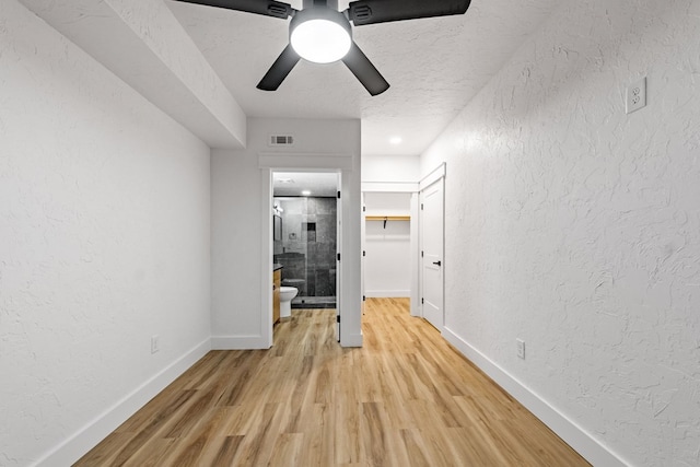 hallway featuring light hardwood / wood-style floors and a textured ceiling