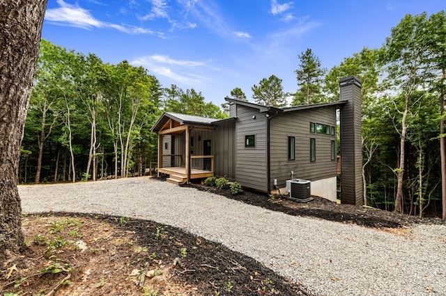 rear view of property featuring covered porch and central air condition unit