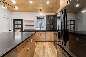 kitchen with sink, dark stone countertops, wooden ceiling, and light hardwood / wood-style floors