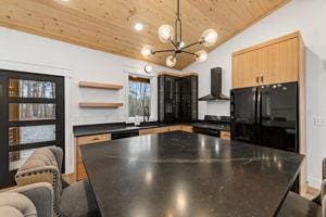 kitchen featuring vaulted ceiling, range, wood ceiling, black fridge, and wall chimney exhaust hood