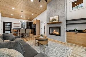 living room featuring wood ceiling, a fireplace, high vaulted ceiling, and light wood-type flooring