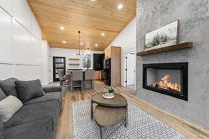 living room with wood ceiling, a fireplace, high vaulted ceiling, and hardwood / wood-style flooring