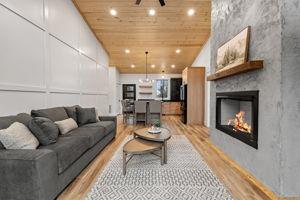 living room with lofted ceiling, a fireplace, wood ceiling, and light hardwood / wood-style flooring