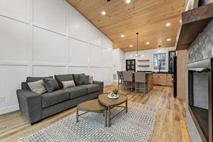 living room featuring lofted ceiling, wooden ceiling, and light hardwood / wood-style flooring