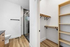 bathroom with vanity, an enclosed shower, hardwood / wood-style flooring, and toilet