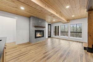 unfurnished living room with wood ceiling, beamed ceiling, and hardwood / wood-style flooring