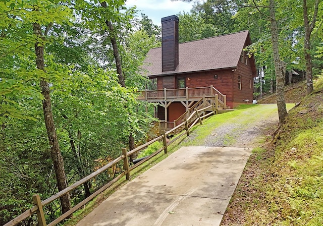 73 Rosiey Ln, Blue Ridge, GA 30513 - view of front of home with a wooden deck, a chimney, stairs, a shingled roof, and driveway