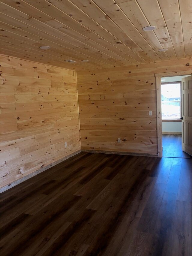 unfurnished room with dark hardwood / wood-style flooring, wood ceiling, and wood walls