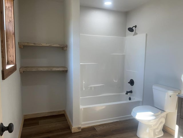 bathroom featuring hardwood / wood-style flooring, shower / washtub combination, and toilet