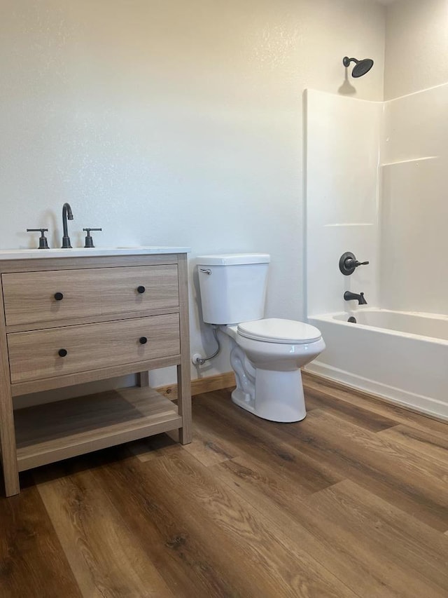 full bathroom featuring vanity, hardwood / wood-style flooring, bathing tub / shower combination, and toilet