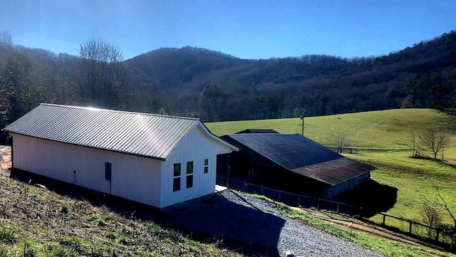 exterior space with a rural view, a mountain view, and a yard