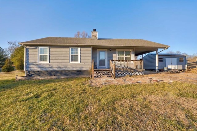 back of house featuring a wooden deck and a lawn