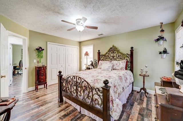 bedroom with ceiling fan, hardwood / wood-style floors, a closet, and a textured ceiling