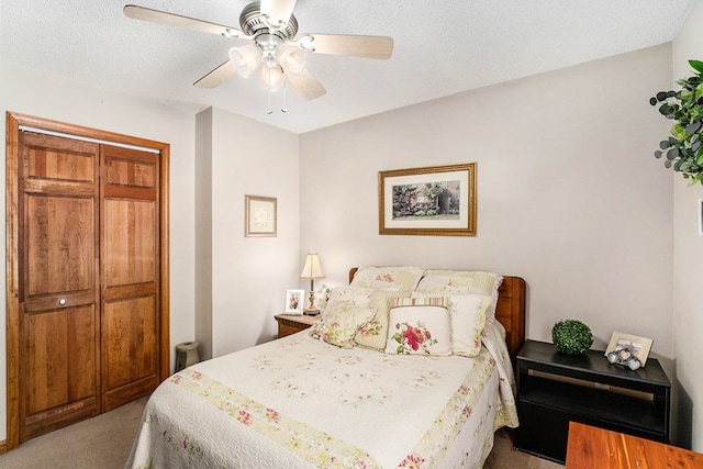 bedroom with ceiling fan, light colored carpet, and a textured ceiling