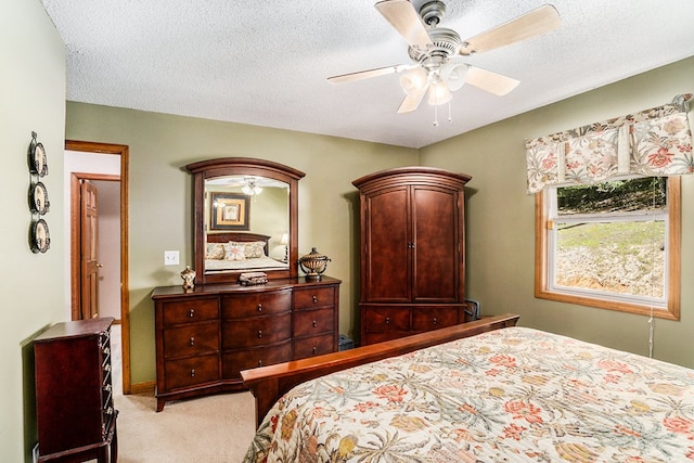 carpeted bedroom featuring ceiling fan and a textured ceiling