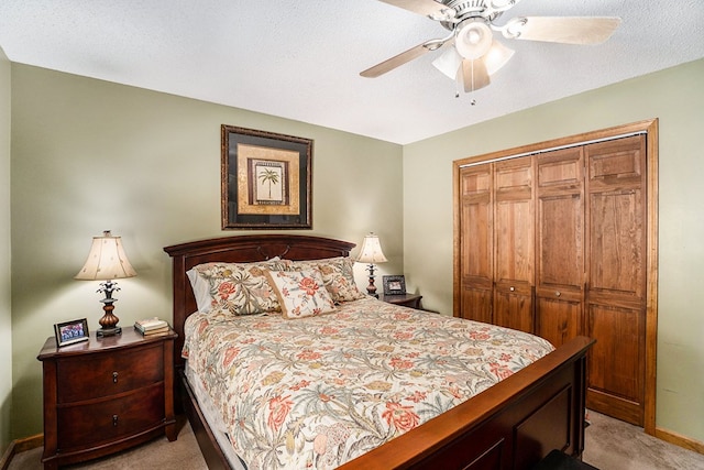 carpeted bedroom featuring ceiling fan, a closet, and a textured ceiling