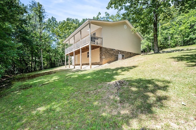 back of property featuring a wooden deck, a yard, and central AC