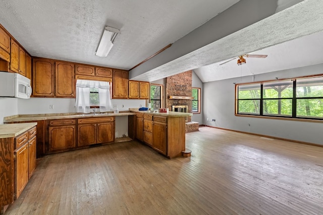 15.20 Piney Acres Rd, Blue Ridge, GA 30513 - kitchen with a peninsula, brown cabinets, ceiling fan, hardwood / wood-style floors, and a sink