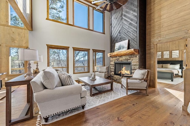 LOT11 Windy Valley Trl, Blue Ridge, GA 30513 - living room featuring a high ceiling, a stone fireplace, hardwood / wood-style floors, a ceiling fan, and plenty of natural light