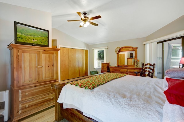 bedroom featuring ceiling fan, light wood-type flooring, and lofted ceiling