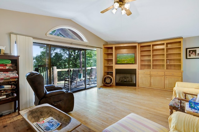 living room with light hardwood / wood-style flooring, lofted ceiling, and ceiling fan