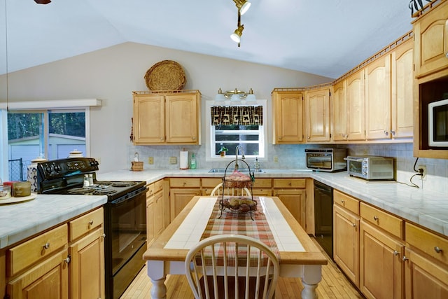 kitchen with tile counters, black appliances, and light hardwood / wood-style floors