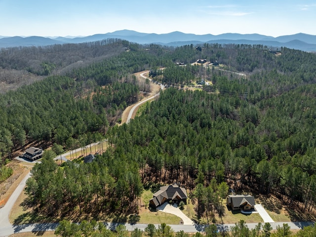 drone / aerial view featuring a mountain view and a view of trees