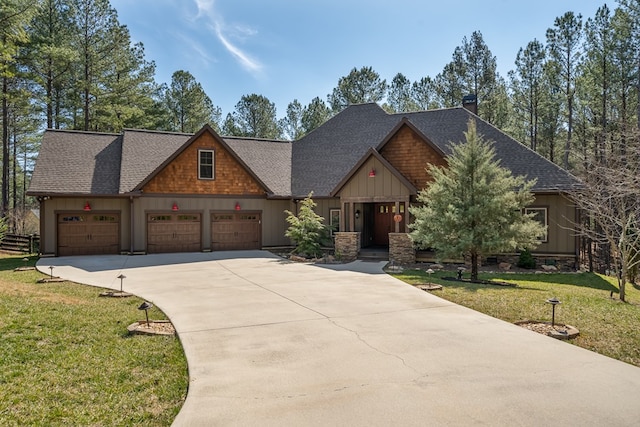 craftsman-style home featuring a front yard, driveway, a shingled roof, a garage, and board and batten siding