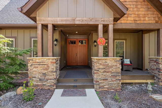 doorway to property featuring a porch, board and batten siding, and a shingled roof