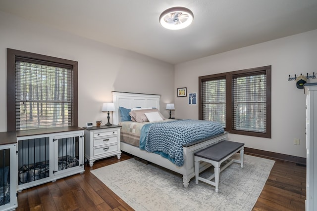 bedroom with dark wood-type flooring and baseboards