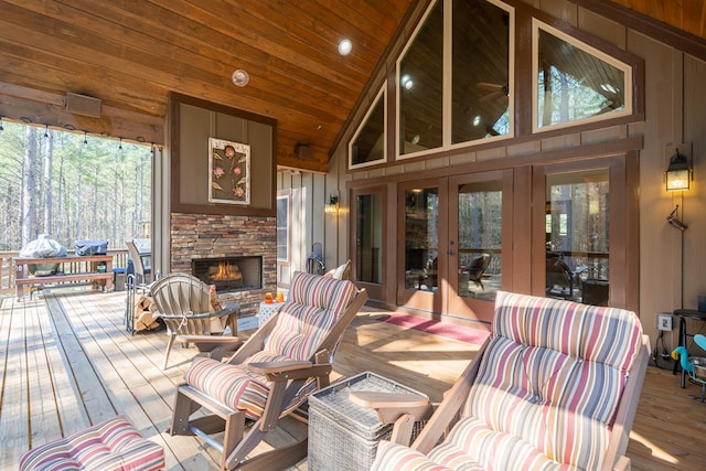 deck with an outdoor stone fireplace and french doors