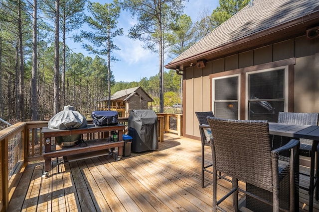 wooden deck featuring outdoor dining space and grilling area