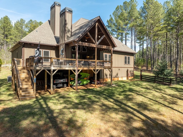 rear view of property featuring stairs, a yard, fence, and a wooden deck