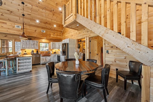 dining space with high vaulted ceiling, dark wood-type flooring, and wooden walls