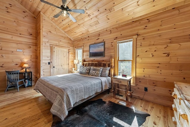 bedroom with light hardwood / wood-style flooring, ceiling fan, high vaulted ceiling, wooden ceiling, and wood walls